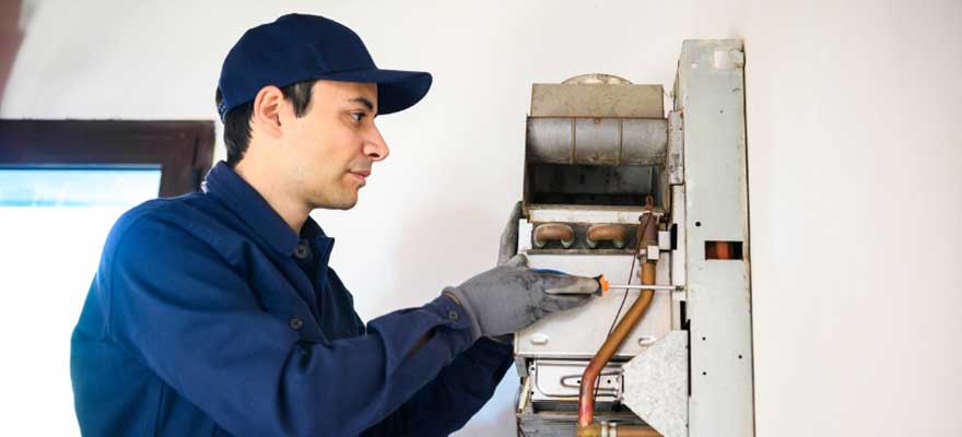 Professional plumber installing a tankless water heater in a Lawrenceville, GA home